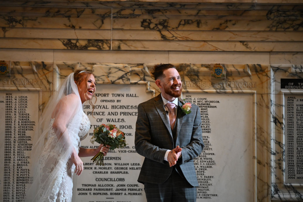 Bride and groom laughing during registry office wedding ceremony